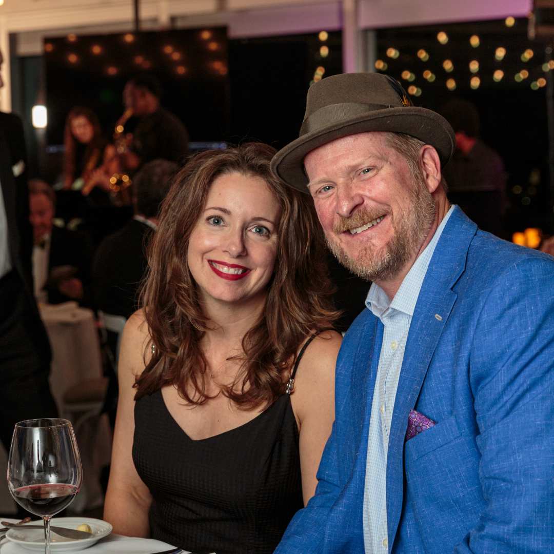 Man and woman smiling sitting at table at gala