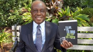 Al Fraser holding a copy of Dizzy Gillespie's auto-biography that he assisted in writing